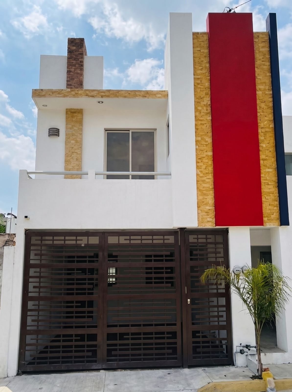Casa terminada de Rinconada de las Flores con columna roja y portón