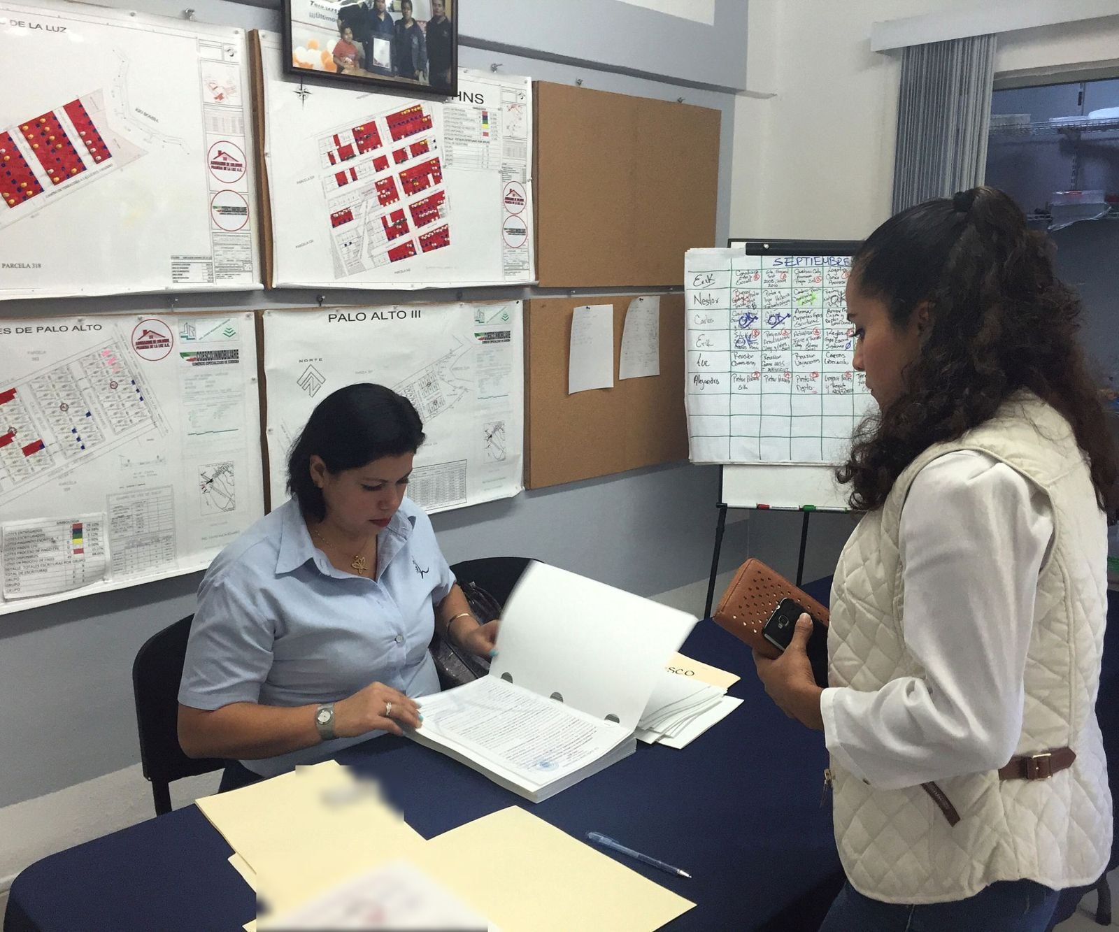 Asesora de COESCO revisa una escritura junto a una clienta