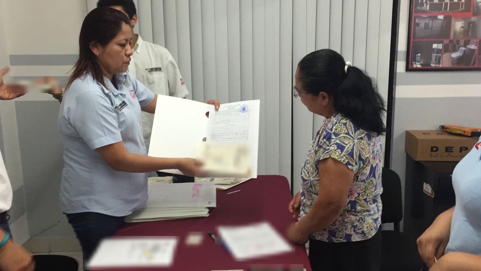 Asesora de COESCO entrega una escritura a una clienta